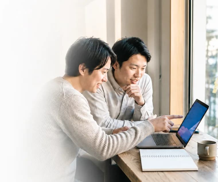 ノートPCを一緒に見る2人の共同創業者